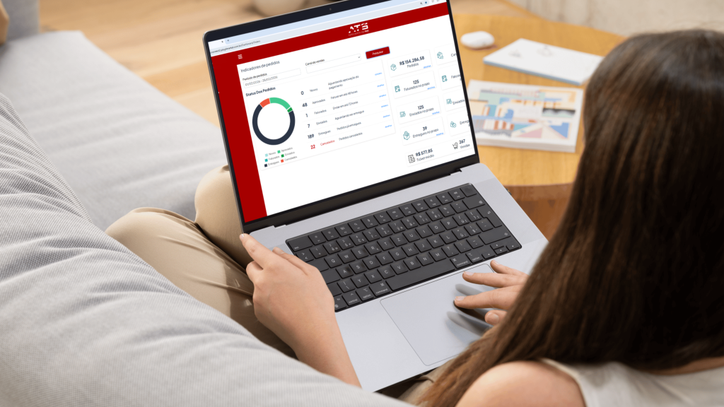 Pessoa usando laptop em sofá com software aberto