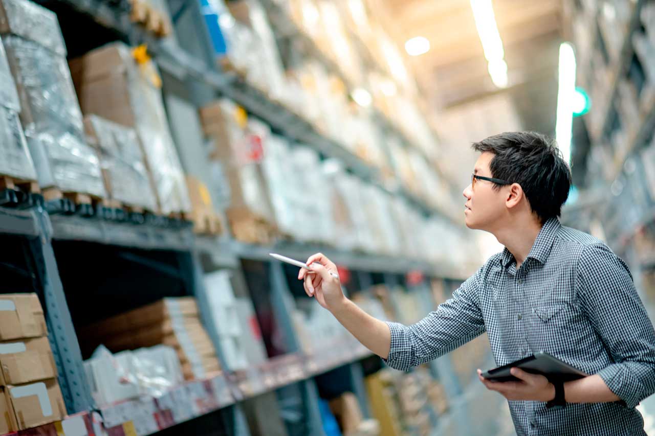 Homem fazendo análise das prateleiras de mercadorias no estoque
