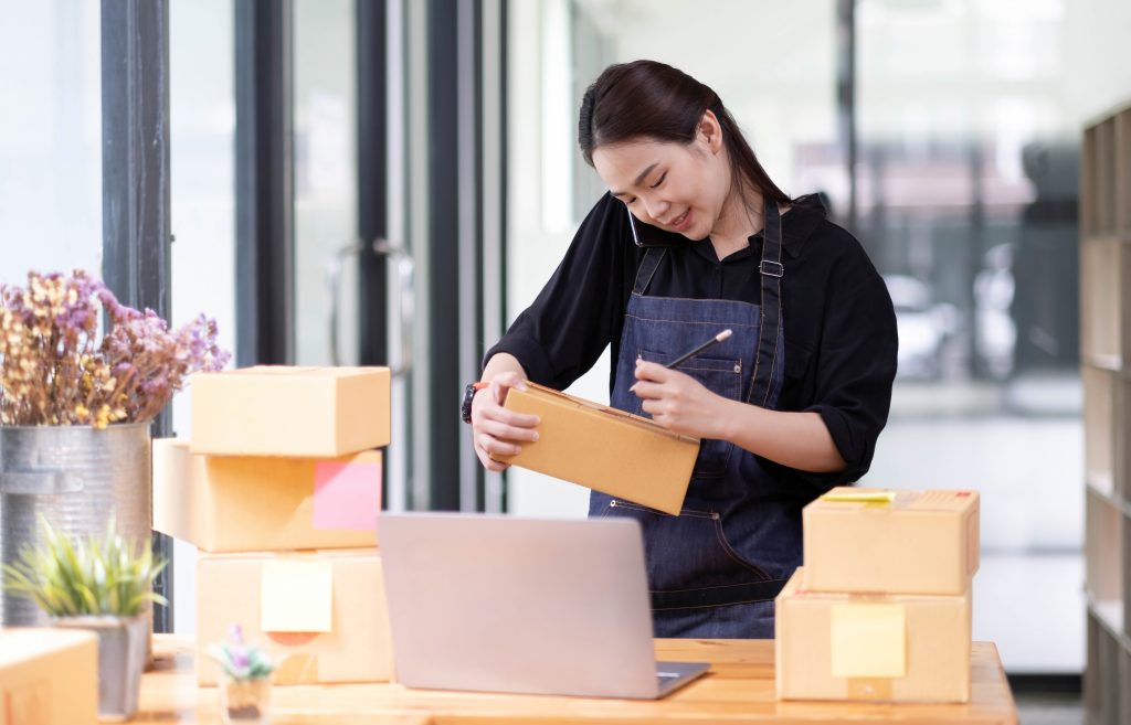 Mulher organizando pacotes em uma mesa de trabalho