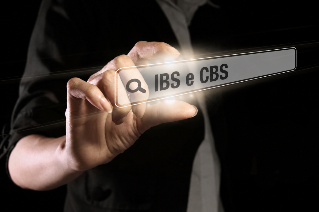Pessoa segurando placa com IBS e CBS iluminados.